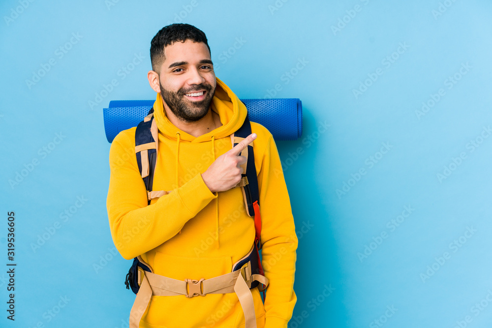 Young arabian traveler backpacker man isolated smiling and pointing aside, showing something at blank space. Young arabian traveler backpacker man isolated smiling and pointing aside, showing something at blank space.