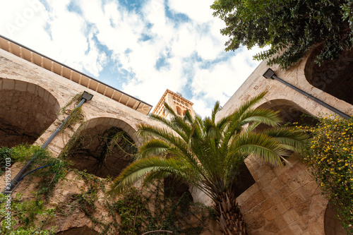 ourtyard with a garden and a building with arches photo