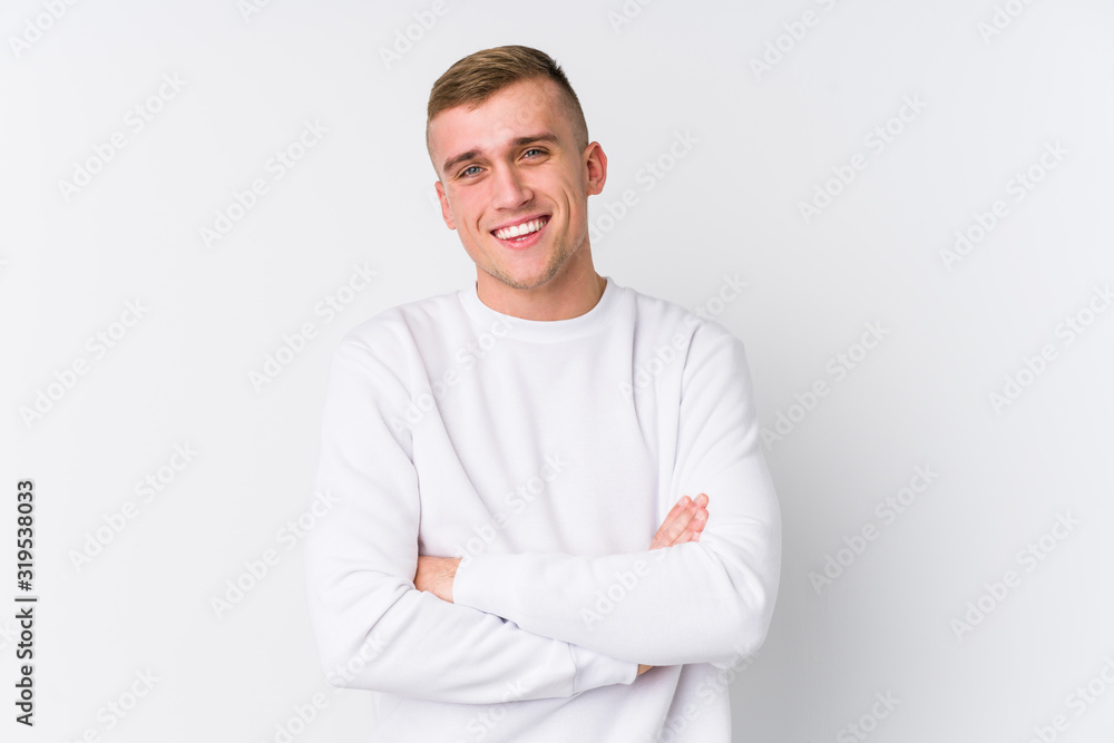 Young caucasian man on white background who feels confident, crossing arms with determination. Young caucasian man on white background who feels confident, crossing arms with determination.