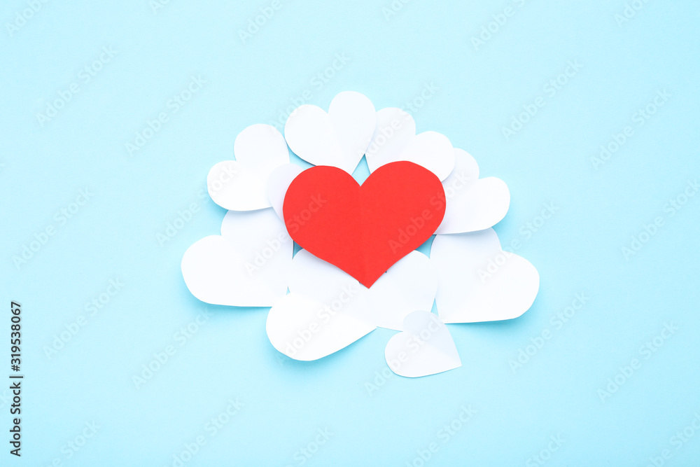 Red and white paper hearts on blue background