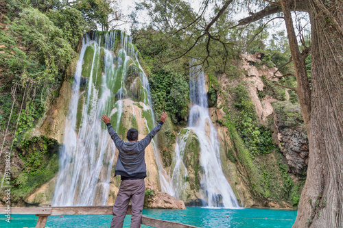 young woman backpacker looking at the waterfall in jungles. photo