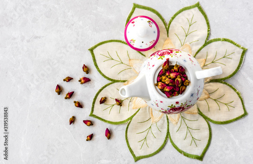 Top view of a cup of tea with dried roses 