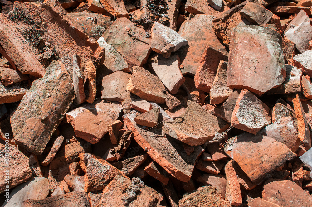 Crushed old ceramic red roof tiles closeup as grunge background Crushed old ceramic red roof tiles closeup as grunge background