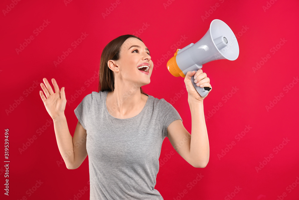 Young woman with megaphone on red background Young woman with megaphone on red background