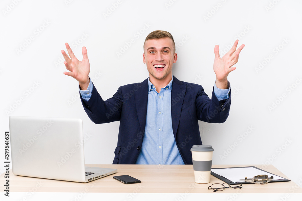 Young business man with a laptop receiving a pleasant surprise, excited and raising hands. Young business man with a laptop receiving a pleasant surprise, excited and raising hands.