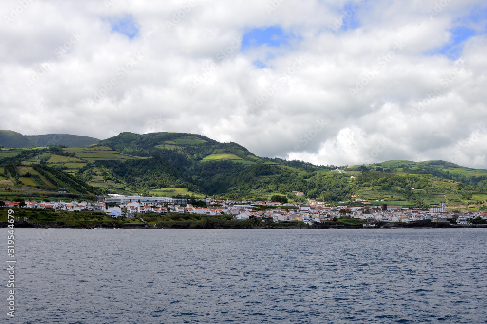 Beautiful white clouds on the blue sky and coast of the city of Ponta Delgada, San Miguel Island, Portugal.