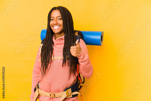 Young african american backpacker woman isolated smiling and raising thumb up