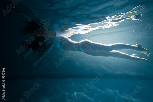 young girl swimming under water