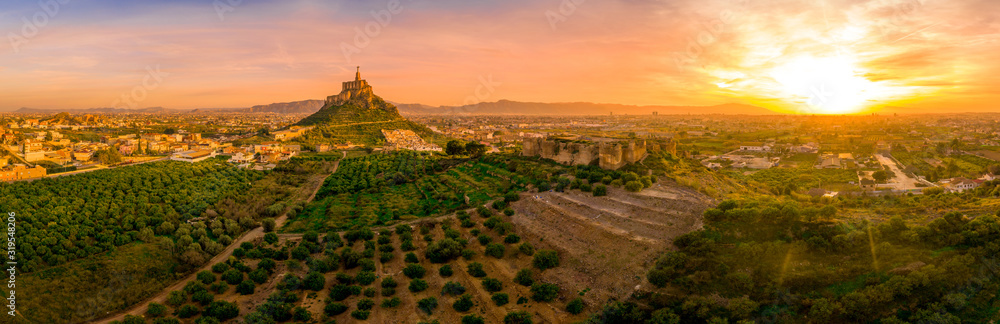 Monteagudo medieval castle ruin twelve rectangular towers circling the hilltop and the sacred heart of Jesus Christ statue on top near Murcia Spain