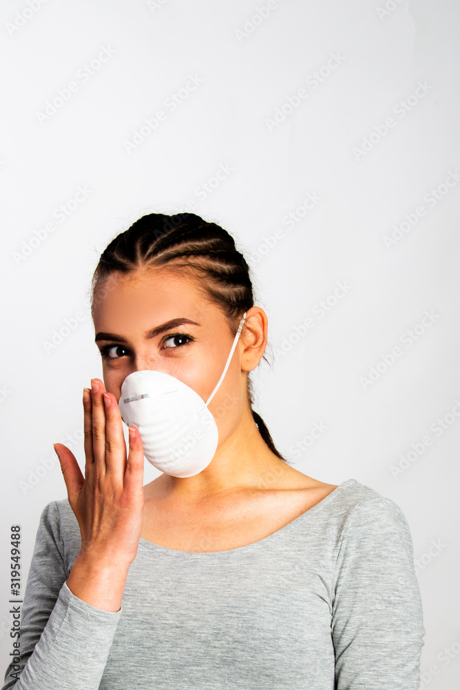 Girl wearing white protective mask over her face. Pollution and virus disease prevention concept Girl wearing white protective mask over her face. Pollution and virus disease prevention concept