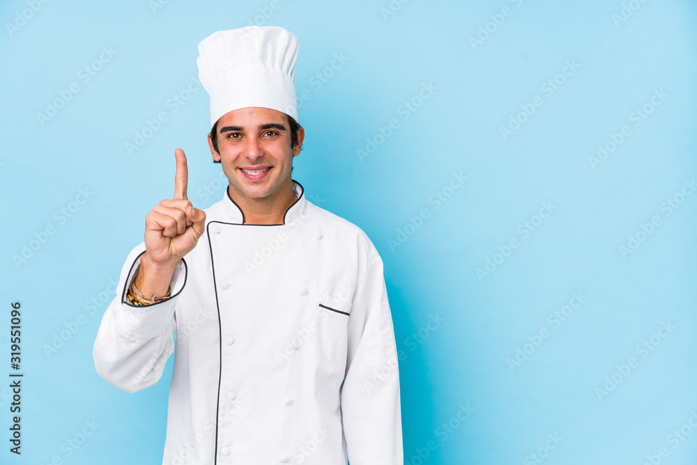 Young cook man isolated showing number one with finger. Young cook man isolated showing number one with finger.