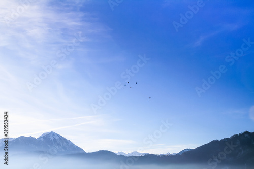 Air Balloons flying in blue sky over misty lake Lucern, Swirtzerland