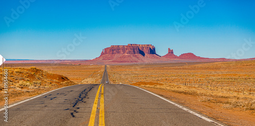 Panoramic picture of endless road in front of majestic rock formation in the Monument Valley National park in winter