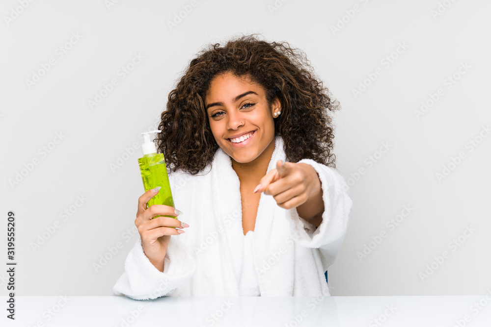 Young african american woman holding an aloe vera cheerful smiles pointing to front. Young african american woman holding an aloe vera cheerful smiles pointing to front.