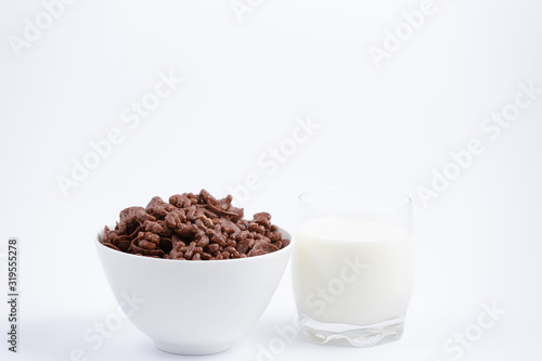 Breakfast cereal, cornflake chocolate in cups and milk is a healthy breakfast that is healthy for the body every day on a white background.