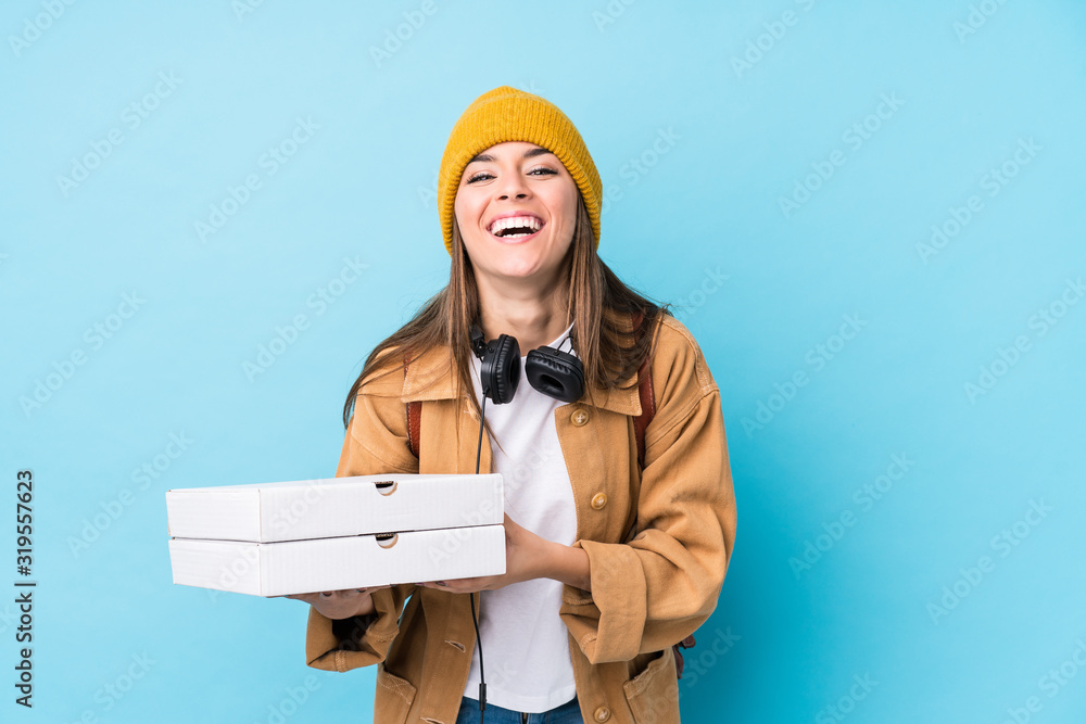 Young caucasian woman holding pizzas isolated laughing and having fun. Young caucasian woman holding pizzas isolated laughing and having fun.