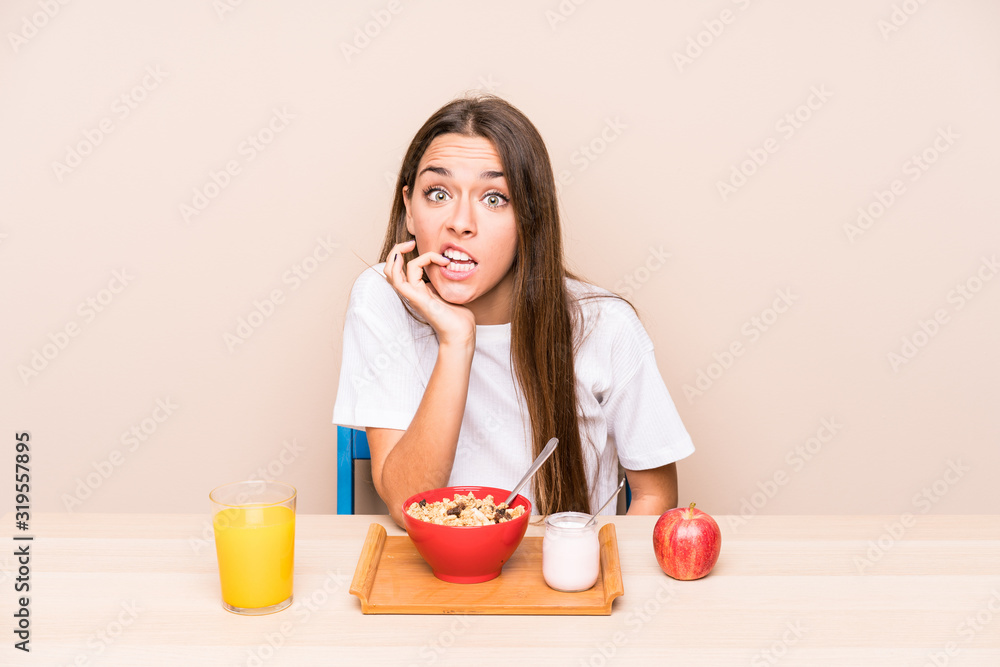 Young caucasian woman having a breakfast isolated biting fingernails, nervous and very anxious. Young caucasian woman having a breakfast isolated biting fingernails, nervous and very anxious.