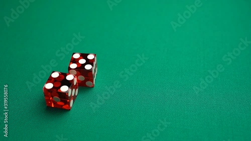 The shooter rolls nine in craps. Slow motion two red dice, craps, thrown on green tomentum background at casino, Nina. Gambling game with random result for adults. photo