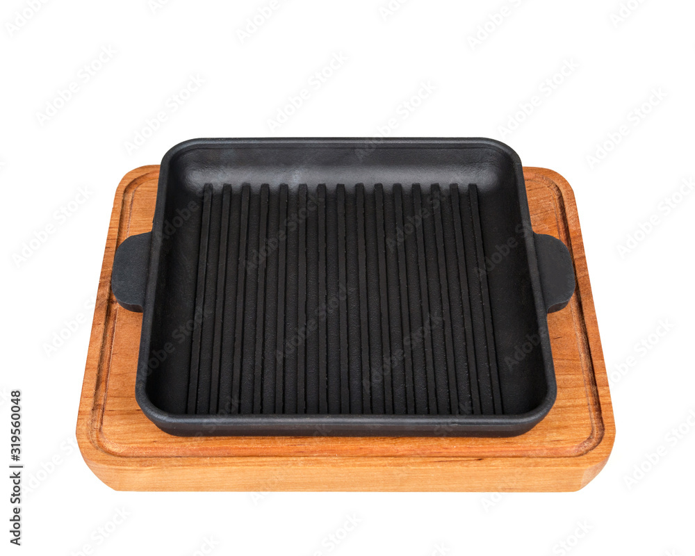 Square, cast iron frying pan on a wooden stand. On white background. Square, cast iron frying pan on a wooden stand. On white background.