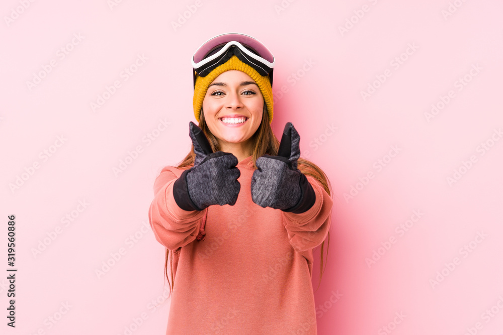 Fototapeta premium Young caucasian woman wearing a ski clothes isolated with thumbs ups, cheers about something, support and respect concept.