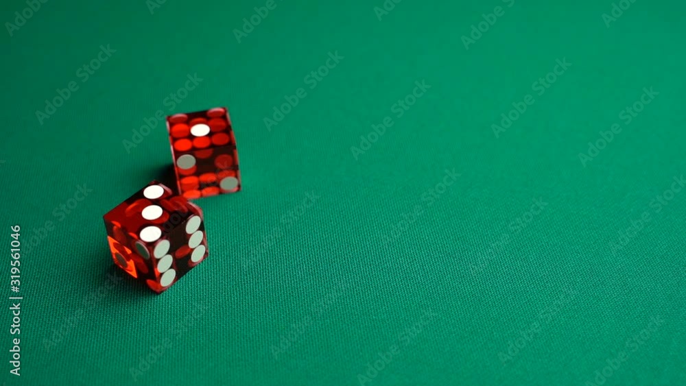 The shooter rolls four in craps. Slow motion two red dice, craps, thrown on green tomentum background at casino, easy four. Gambling game with random result for adults. The shooter rolls four in craps. Slow motion two red dice, craps, thrown on green tomentum background at casino, easy four. Gambling game with random result for adults.