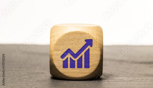 Icone croissance / économie gravé sur un cube en bois, isolé sur une ardoise