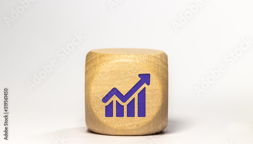 Icone croissance / économie gravé sur un cube en bois, isolé sur fond blanc 