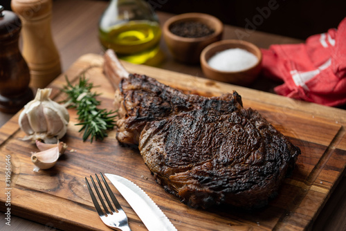 grilled tomahawk steak on wooden plate ready for eat