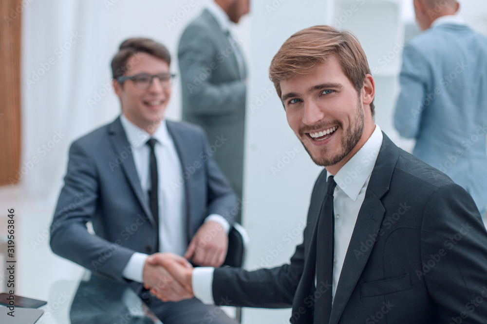 happy entrepreneur shaking hands with his business partner happy entrepreneur shaking hands with his business partner