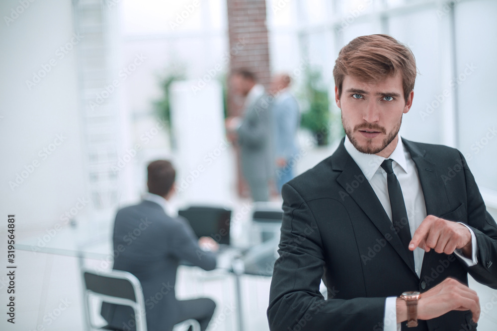 serious businessman pointing to his wrist watch. serious businessman pointing to his wrist watch.