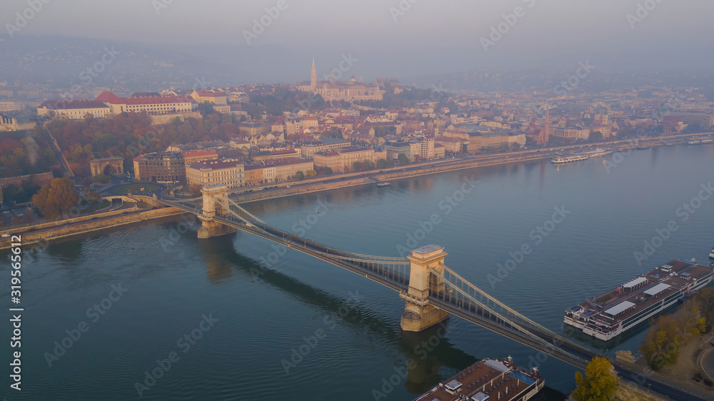 An early morning sunrise on the city capital of Hungary, Budapest. top view drone. Chain bridge on the river Danube. Views towards the fishing bastion and the palace.