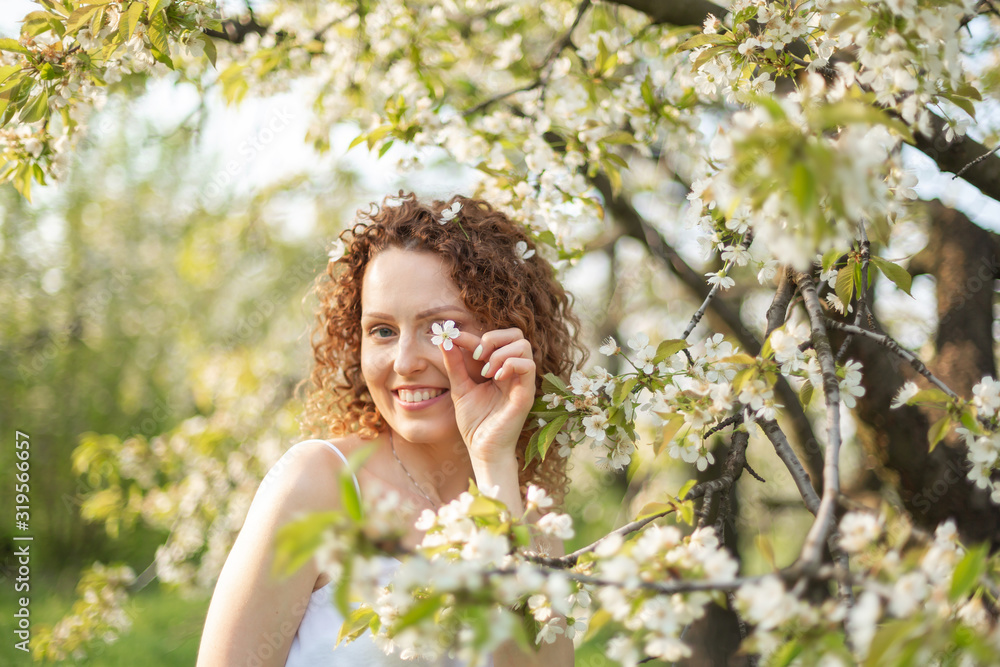 Young attractive girl walks in spring green park enjoying flowering nature. Healthy smiling girl spinning on the spring lawn. Allergy without Young attractive girl walks in spring green park enjoying flowering nature. Healthy smiling girl spinning on the spring lawn. Allergy without