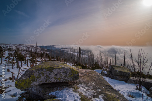 Sun shining through the trees and clouds. Winter trip to Plechy and Trojmezi, Šumava national Park. photo