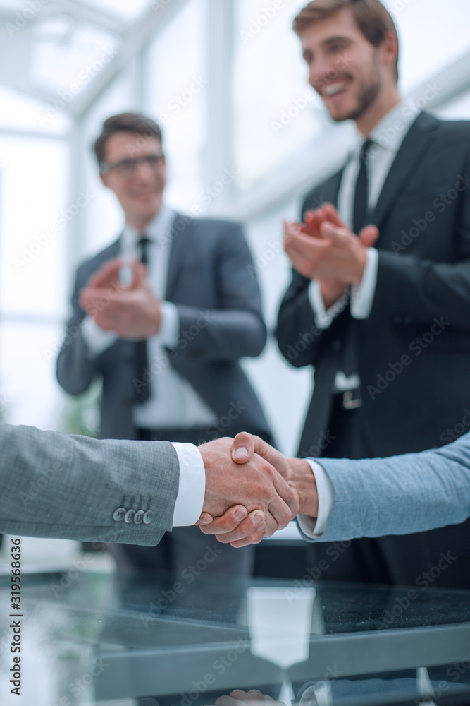 close up. business partners shaking hands after signing the contract. close up. business partners shaking hands after signing the contract.