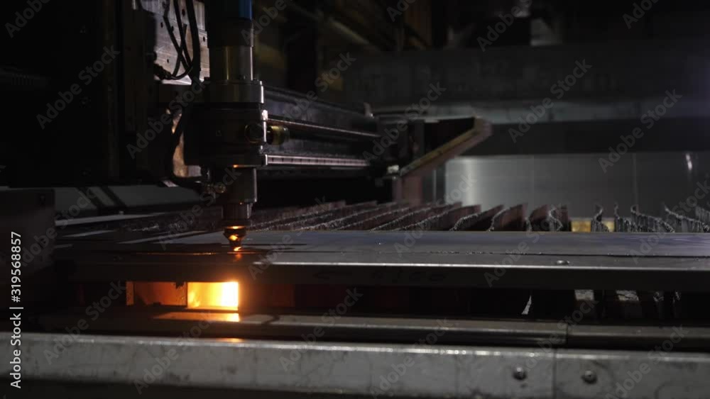 automated laser cutting of metal with more sparks in a poorly lit room automated laser cutting of metal with more sparks in a poorly lit room
