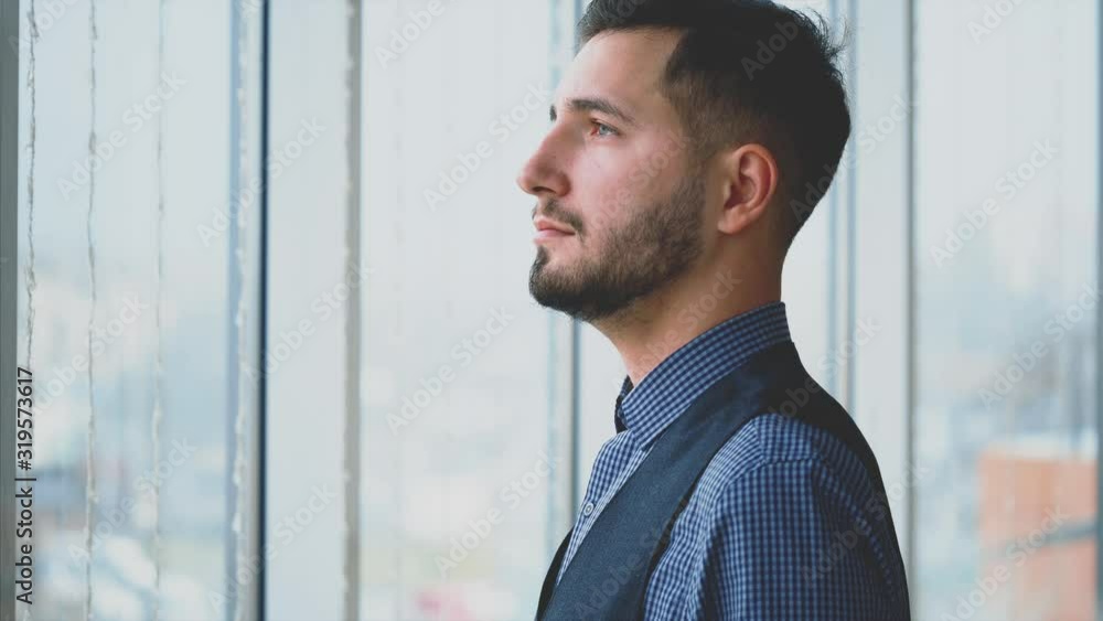 Businessman in formal suite stands in front of panoramic window with city view. Profile view. Outboard profile. Close up. Animation. 4K. Businessman in formal suite stands in front of panoramic window with city view. Profile view. Outboard profile. Close up. Animation. 4K.