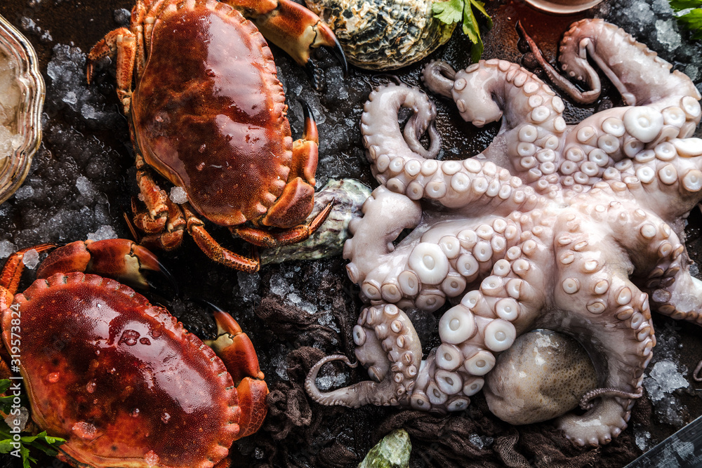 Zusammenstellung von Meeresfrüchten mit feinschmeckerischem Abendessenhintergrund der rohen frischen Krake,austern und mit roten krabben