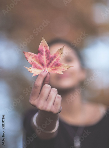 young woman holding an autumn leaf