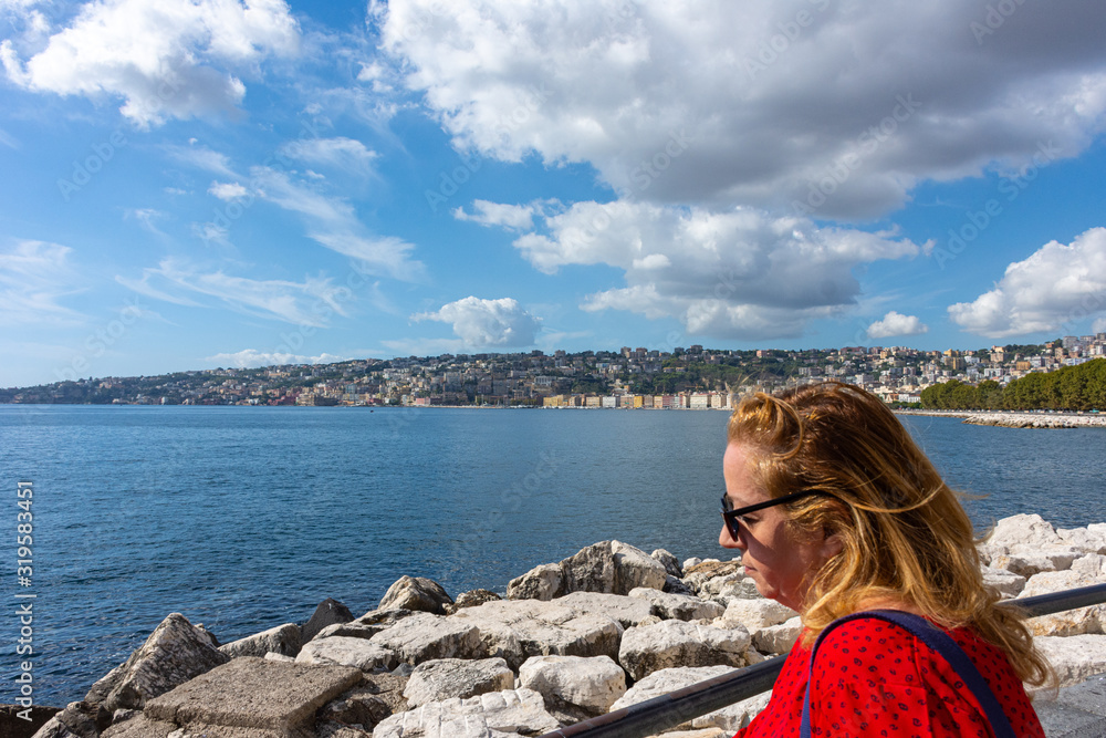 Italy, Naples, 7 October 2019, blonde tourist poses on the waterfront 