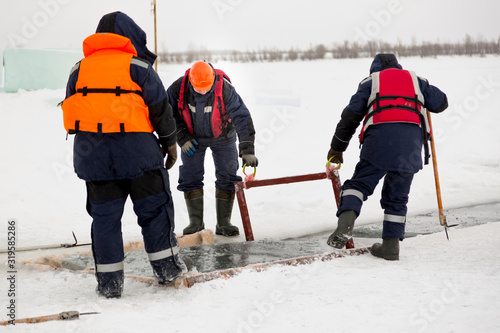 Workers catch ice blocks in the lane