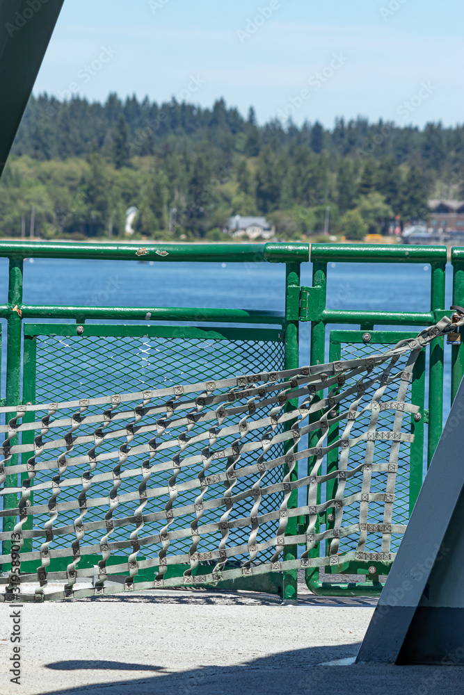 gray safety netting and green metal railing on side of washington state ferry
