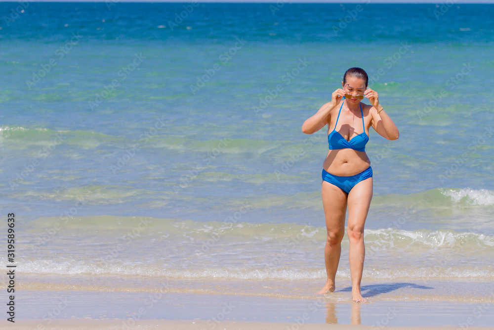 Fototapeta premium Woman and bikini blue pretty with sunlight on beach