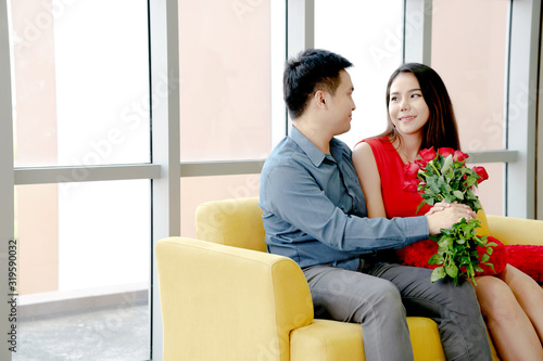 Happy loving couple. husband gives his wife flowers at home