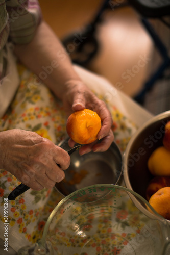 Grandma peeling fresh peaches