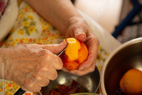 Grandma peeling fresh peaches