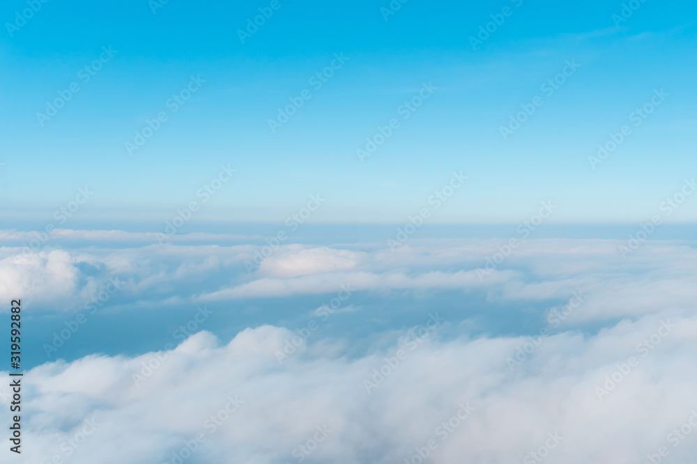 Airplane window view above beautiful white cloud summer blue sky and sun light abstract nature.