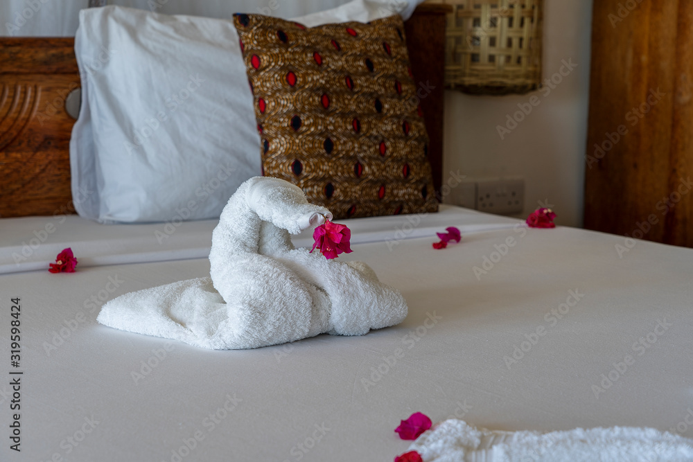 Obraz premium Beautiful swan from white bath towel decorate on bed, nice greeting from hotel