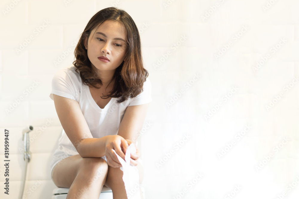 Closeup woman sitting on toilet in the morning with depressed feeling, selective focus Closeup woman sitting on toilet in the morning with depressed feeling, selective focus