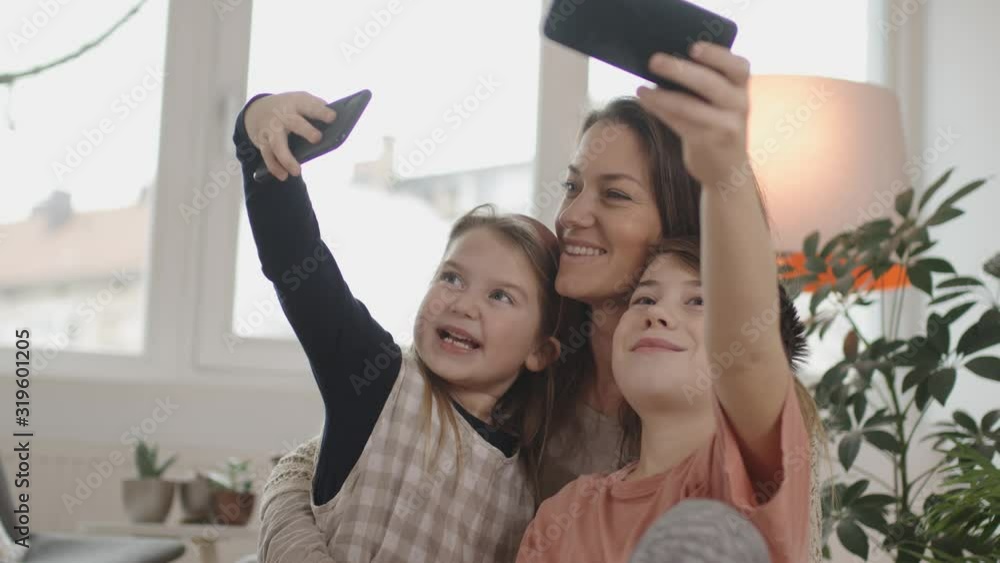 mother and two kids making a selfie in their new home. Beautiful living room. Shot in Slovenia mother and two kids making a selfie in their new home. Beautiful living room. Shot in Slovenia
