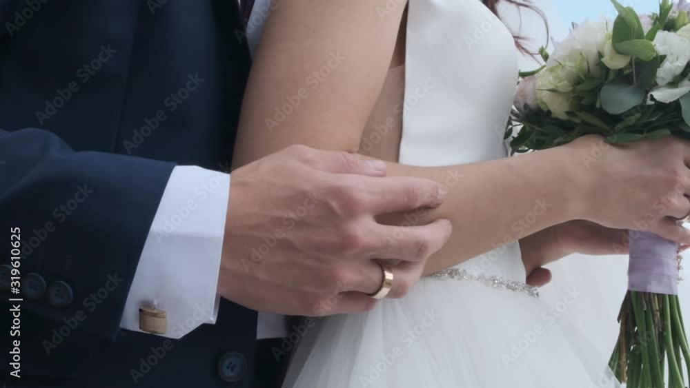 hands of bride and groom with rings on wedding bouquet hands of bride and groom with rings on wedding bouquet